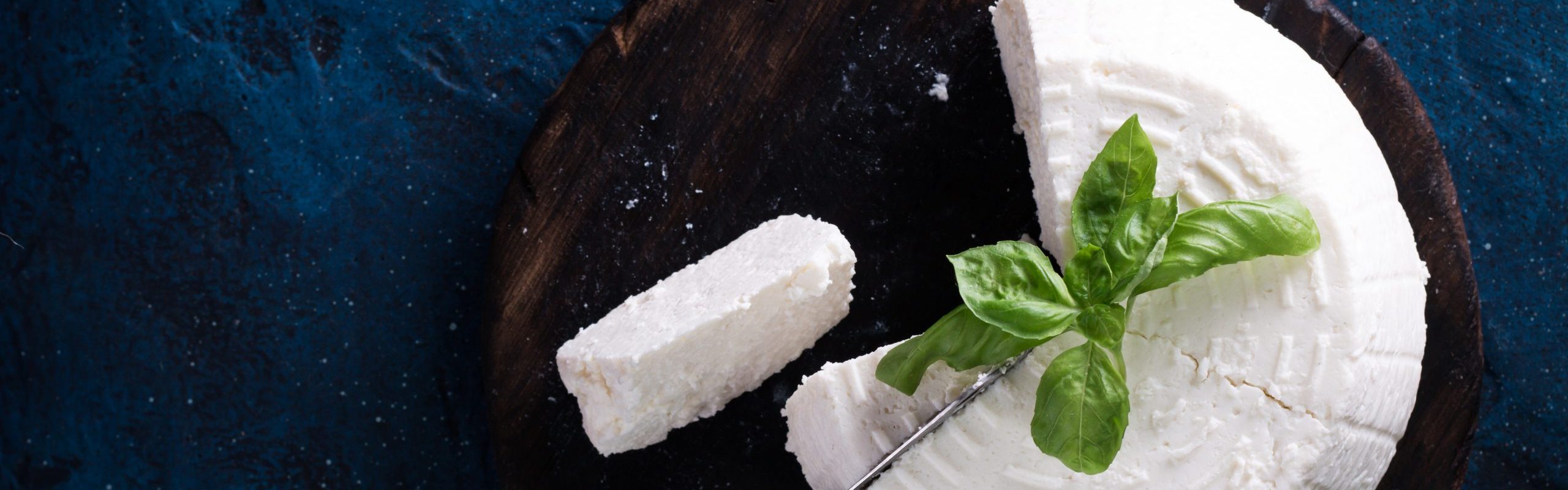 A fresh ricotta with basil leaf on wooden table italian food concept