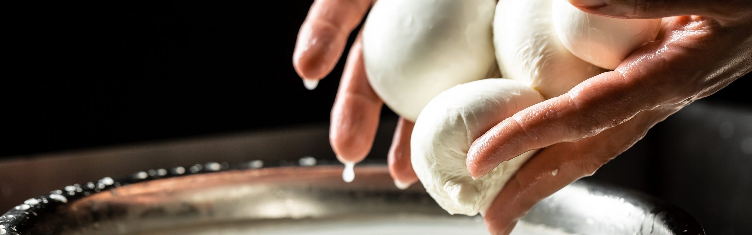 A woman working in a small family creamery is processing the final steps of making a cheese. Italian hard cheese silano or caciocavallo, mozzarella.